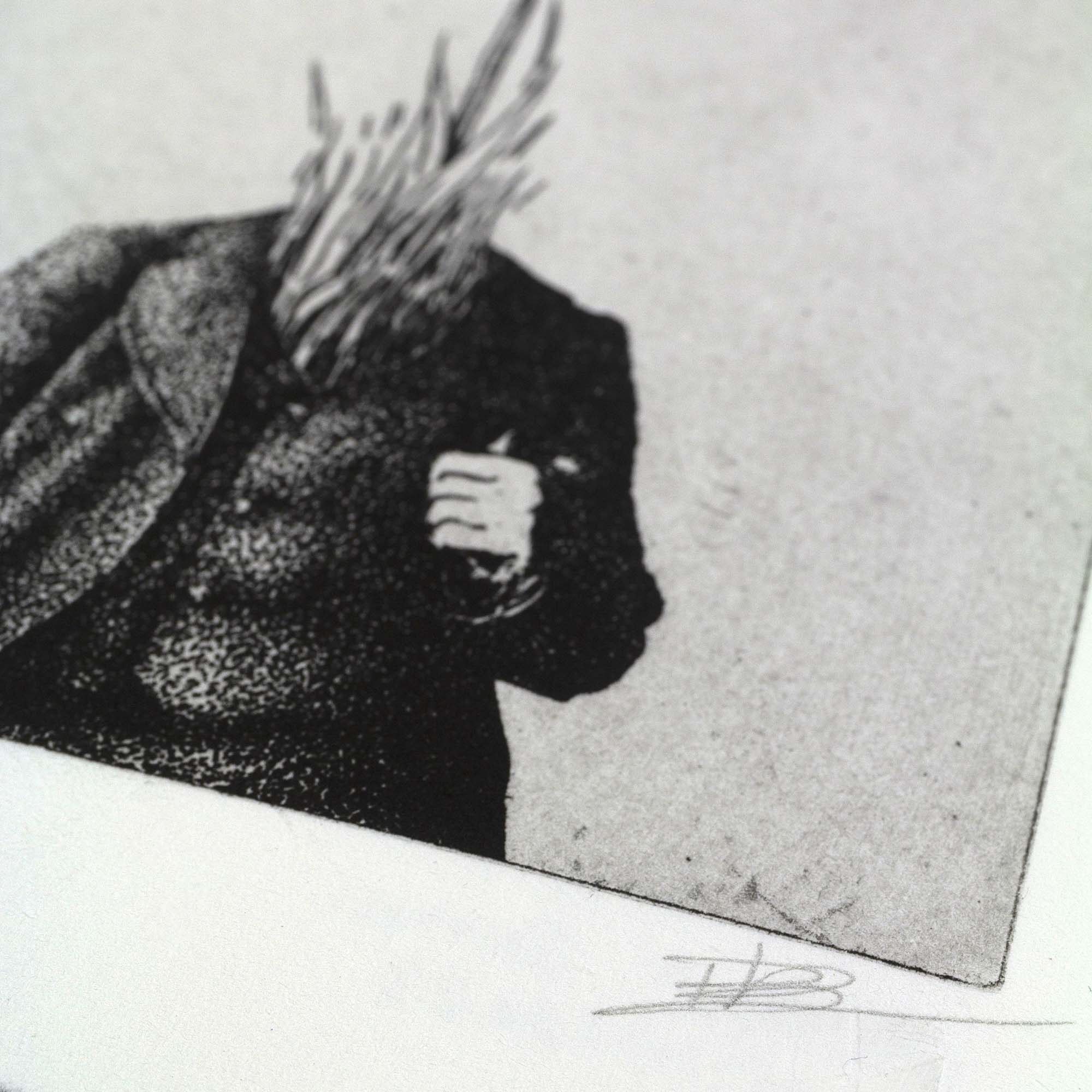 Gravure surréaliste "Bellis perennis" dans un grand cadre noir fin, posée au sol sur un parquet en bois clair contre un mur blanc. L'œuvre verticale montre un personnage en costume dont la tête est remplacée par une grande marguerite sur fond bleu.