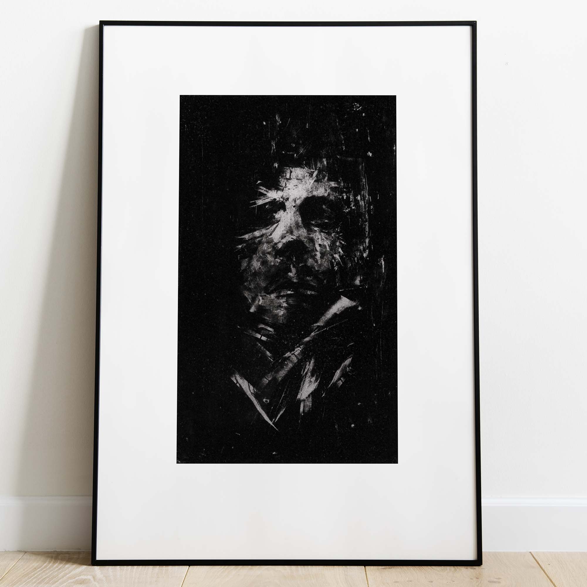 Gravure expressionniste en noir et blanc "Portrait" dans un grand cadre noir fin avec un passe-partout blanc, posée au sol sur un parquet clair contre un mur blanc.