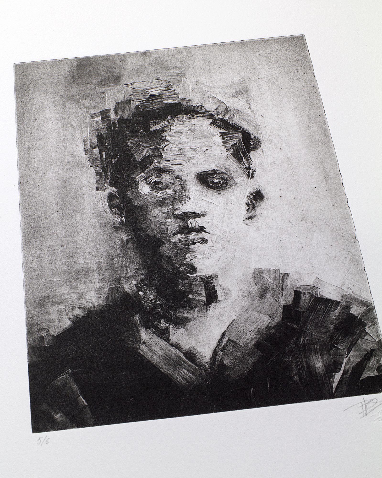 Gravure originale en noir et blanc intitulée Portrait V par l'artiste Clément Scarpi, représentant le visage mélancolique et fragmenté d'un jeune homme de face au regard sombre, présentée sous cadre noir.