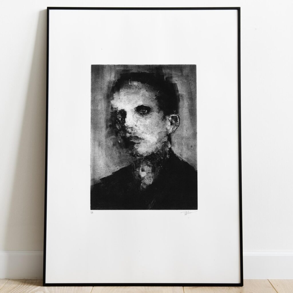 Gravure originale en noir et blanc intitulée Portrait VI par l'artiste Clément Scarpi, représentant le visage sombre et expressif d'un jeune homme de trois-quarts au regard intense, présentée sous cadre noir.