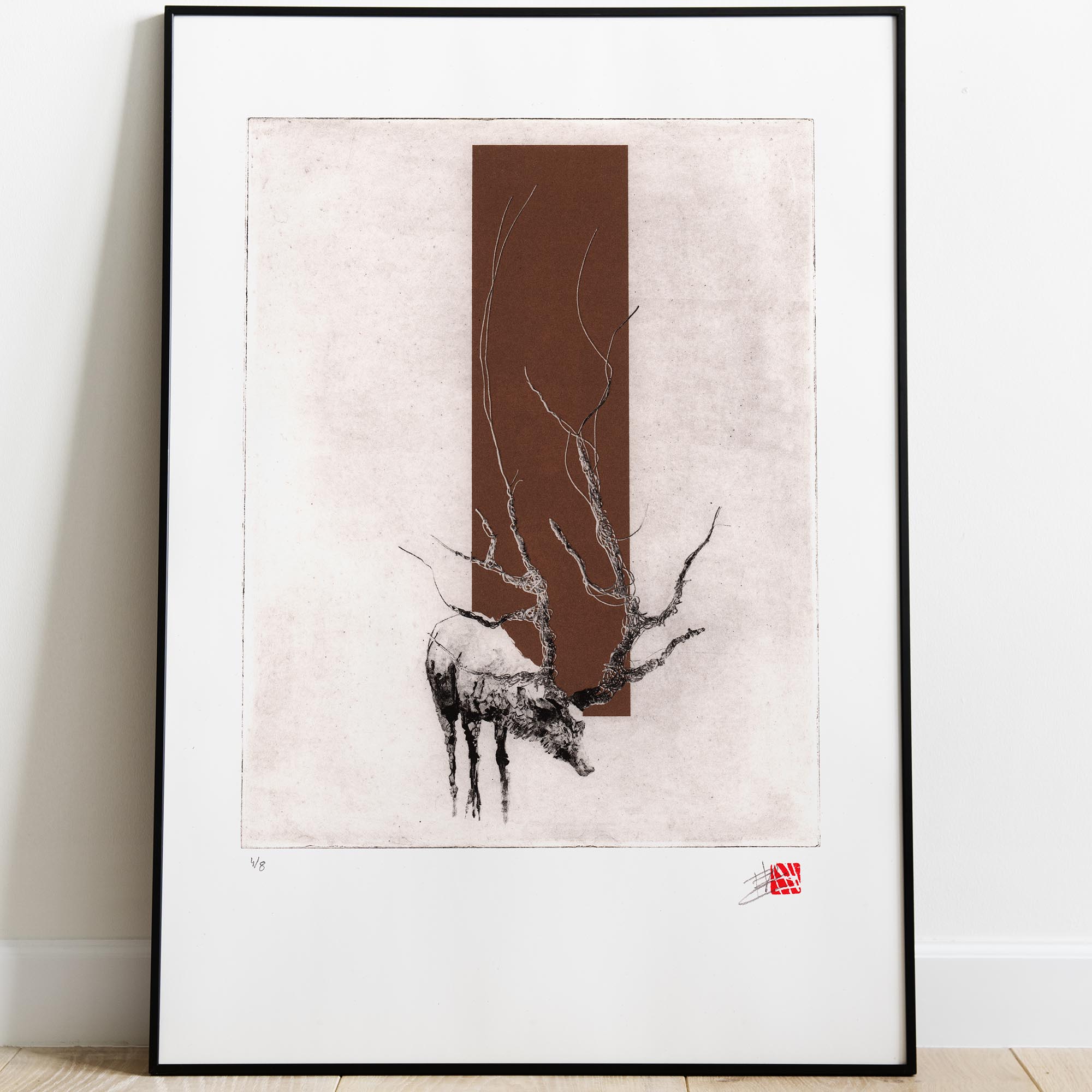 Gravure originale d'art contemporain The Deer de Clément Scarpi. Estampe d'art représentant un cerf aux bois texturés semblables à des branches d'arbres, superposé sur un rectangle vertical or, imprimée sur papier d'art blanc à bords frangés avec signature, sceau rouge et numérotation d'arti