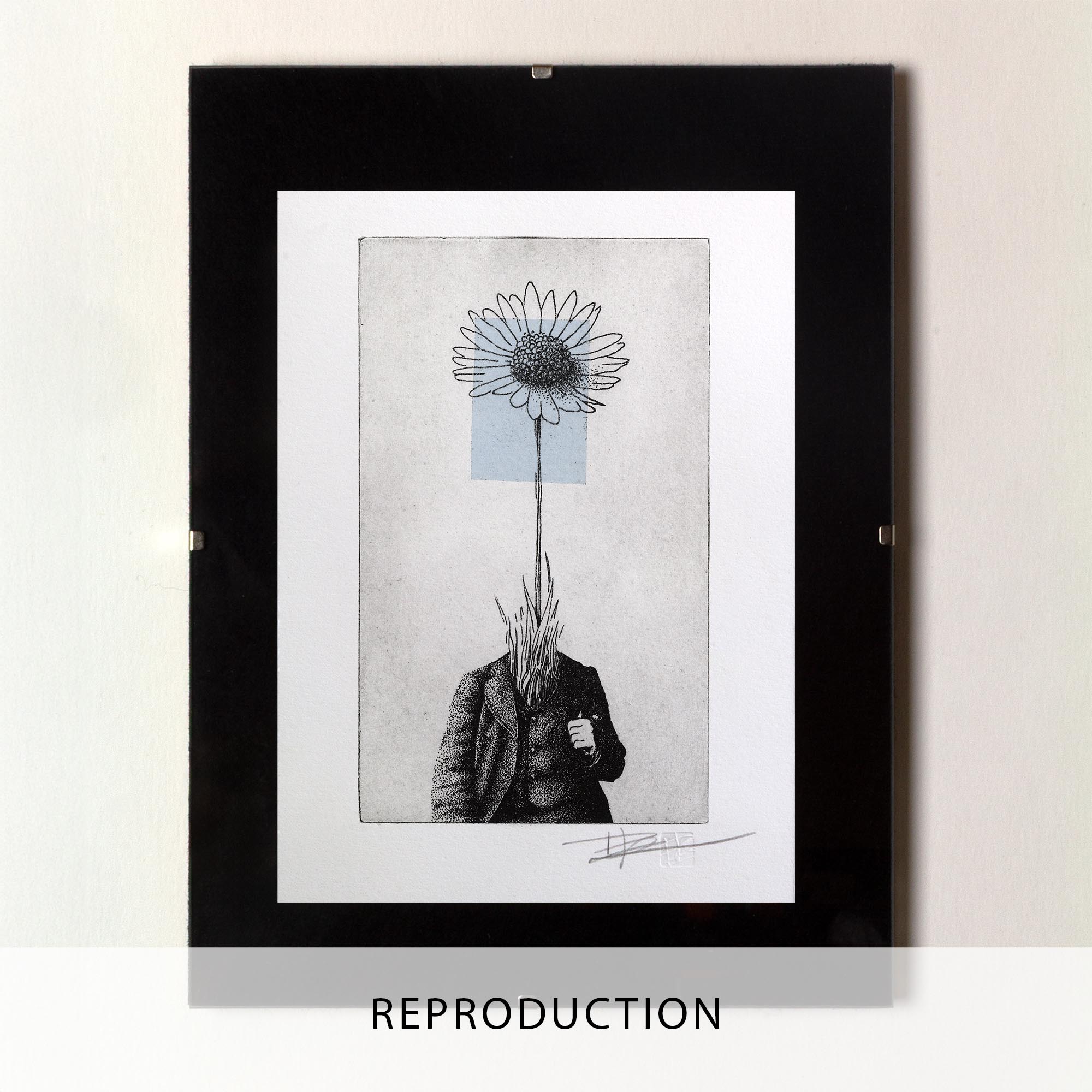 Gravure surréaliste "Bellis perennis" dans un grand cadre noir fin, posée au sol sur un parquet en bois clair contre un mur blanc. L'œuvre verticale montre un personnage en costume dont la tête est remplacée par une grande marguerite sur fond bleu.