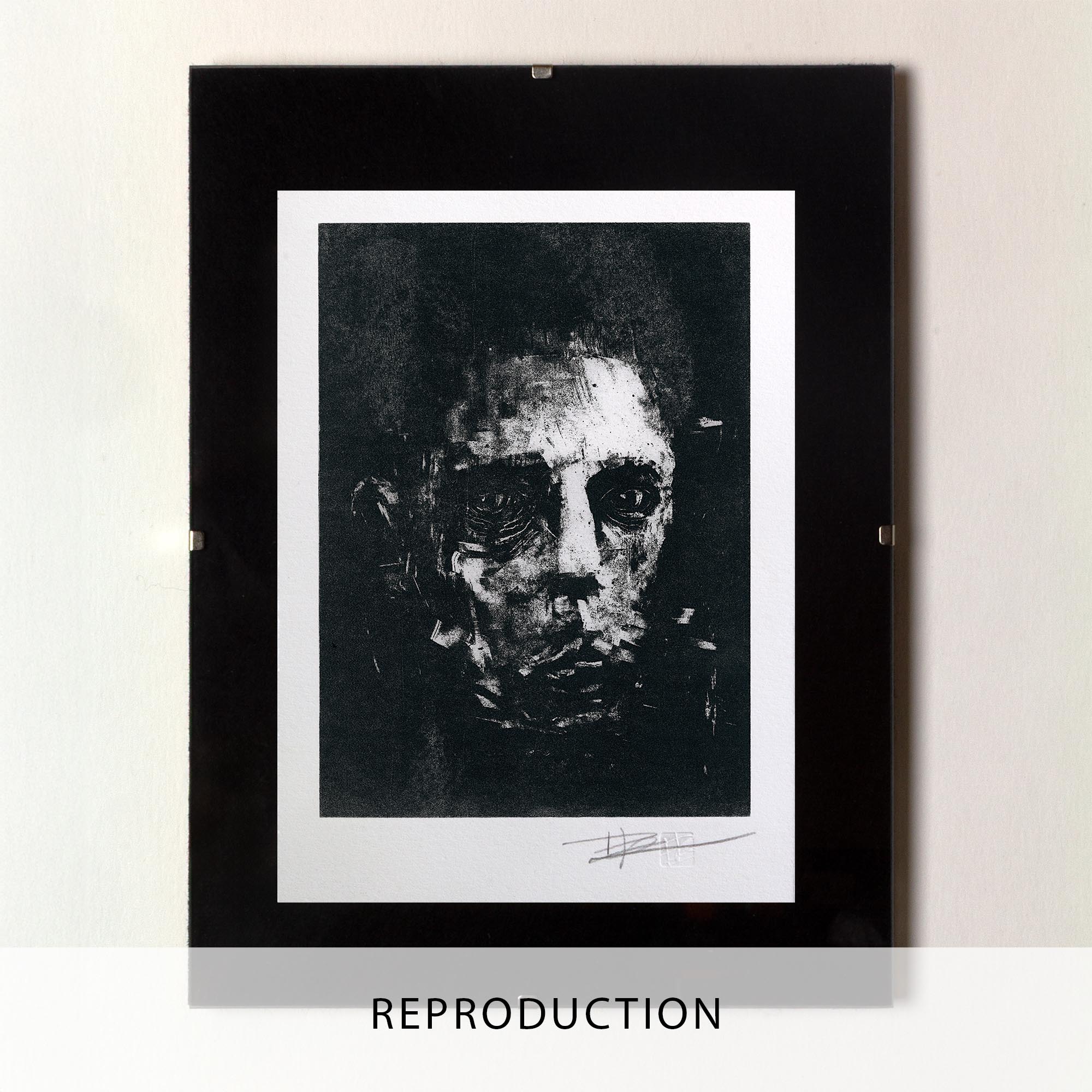 Mise en situation d'un grand cadre noir rectangulaire posé sur un sol en parquet de bois clair contre un mur blanc. À l'intérieur, un large passe-partout blanc met en valeur une estampe verticale à l'encre noire. L'illustration montre un visage masculin fragmenté et ténébreux, émergeant de touches d'encre texturées et de lignes gravées à l'esthétique brute et mélancolique. Sous la gravure, on distingue les inscriptions au crayon « EA » à gauche et la signature de l'artiste à droite.